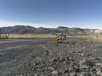 the roadway is empty on both sides of the desert as there are mountains in the distance