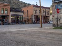 a red fire hydrant sitting in front of an old store window and building next to an open air field