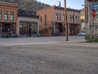 a red fire hydrant sitting in front of an old store window and building next to an open air field