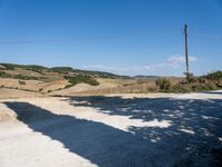 a motorcycle parked in front of a car on a dirt road next to the side of a hill