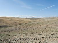 a person on a hill with no wheels going around the tracks and sand dunes to be covered by grass and dirt