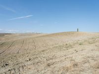 a person on a hill with no wheels going around the tracks and sand dunes to be covered by grass and dirt