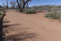 this is an image of a dirt road in the desert during the day with clouds