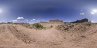 a camera lens with dirt track and a mountain in the distance through the panorama lens