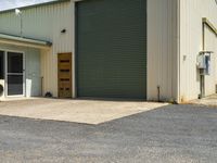 a dog in the driveway of an industrial warehouse or storage space with a large door