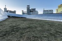 the outside of the building is designed to look like an oculus of architecture with curved metal walls, grass and lawn