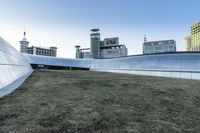 the outside of the building is designed to look like an oculus of architecture with curved metal walls, grass and lawn