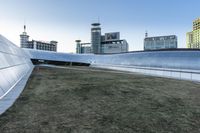 the outside of the building is designed to look like an oculus of architecture with curved metal walls, grass and lawn