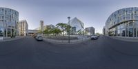 car traveling in front of modern glassy building on curved roadway in downtown city area