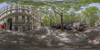 a 360 - view of a street with buildings, trees and a bus on the side