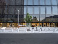 a row of bikes parked next to a tall building next to some steps and trees