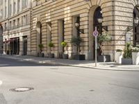 a stop sign in front of an old fashioned building near a street corner with tables and umbrellas