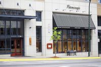 a large building with two benches outside it, and an empty sidewalk with no traffic