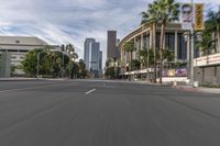 a photo of downtown buildings on a sunny day in las vegas with the cars moving through