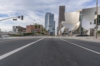 a photo of downtown buildings on a sunny day in las vegas with the cars moving through