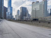 an empty highway on a street with several tall buildings in the background and a yellow van driving along it