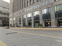 yellow line in the road next to a tall building with large windows and a street light near