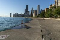 there are some graffiti on the concrete and in front of a lake and many skyscrapers