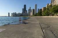 there are some graffiti on the concrete and in front of a lake and many skyscrapers