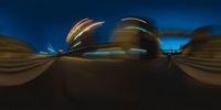 blurred image of city lights from the street in front of an upside down skateboarder