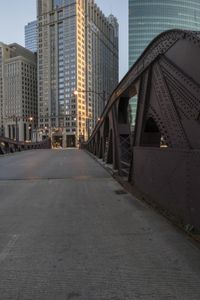 a very wide bridge with some cars on it in the city setting sun on the street