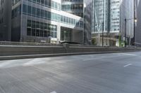 a woman riding her skateboard in the middle of a city street by tall buildings