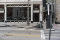 two cars parked on the side of a road in front of a store front,