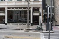 two cars parked on the side of a road in front of a store front,