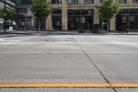 this is an intersection with many trees and people walking in it and two signs on the corner of it