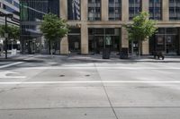 this is an intersection with many trees and people walking in it and two signs on the corner of it