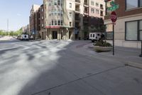 a street view of a wide city street with buildings and cars behind it and a stop sign