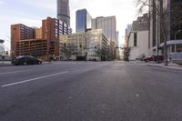 a road that has a few cars going around it and some buildings in the back ground