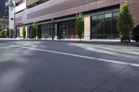 an empty street in the city with buildings on either side of it and cars parked in front