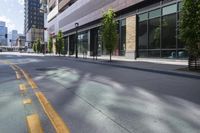 an empty street in the city with buildings on either side of it and cars parked in front