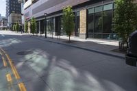 an empty street in the city with buildings on either side of it and cars parked in front