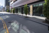 an empty street in the city with buildings on either side of it and cars parked in front