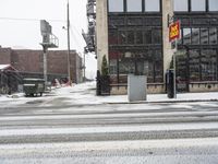 a traffic light on a snowy sidewalk in front of buildings and shops on a city street