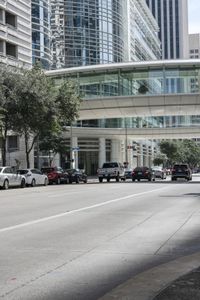 a road with cars parked on both sides of it next to tall buildings in the middle