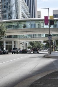 a road with cars parked on both sides of it next to tall buildings in the middle