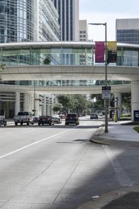 a road with cars parked on both sides of it next to tall buildings in the middle