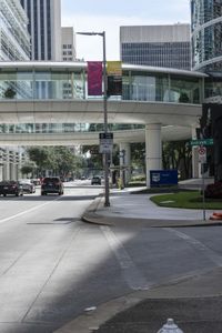 a road with cars parked on both sides of it next to tall buildings in the middle