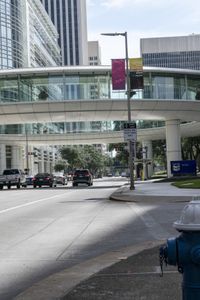 a road with cars parked on both sides of it next to tall buildings in the middle