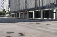 an empty road, with a car parked on it and a tall building with windows