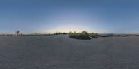 a 360 - vr image with the sun in the distance behind the camera lens, from a snow covered landscape