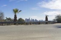 the view of downtown los from an overlook with a bench on it, overlooking the valley and city