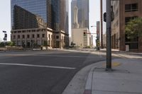 an empty city street with tall buildings and street signs in the background under a hazy sky