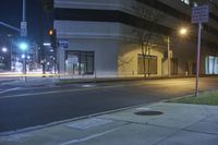 a couple of empty street signs sitting on a corner by a building at night or in the dark