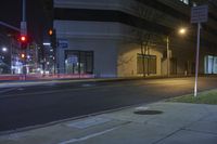 a couple of empty street signs sitting on a corner by a building at night or in the dark