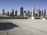 this is an empty building roof in front of a city skylinescape that is in the distance