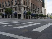 an empty street has an ornate building on one side, and a red brick building on the other